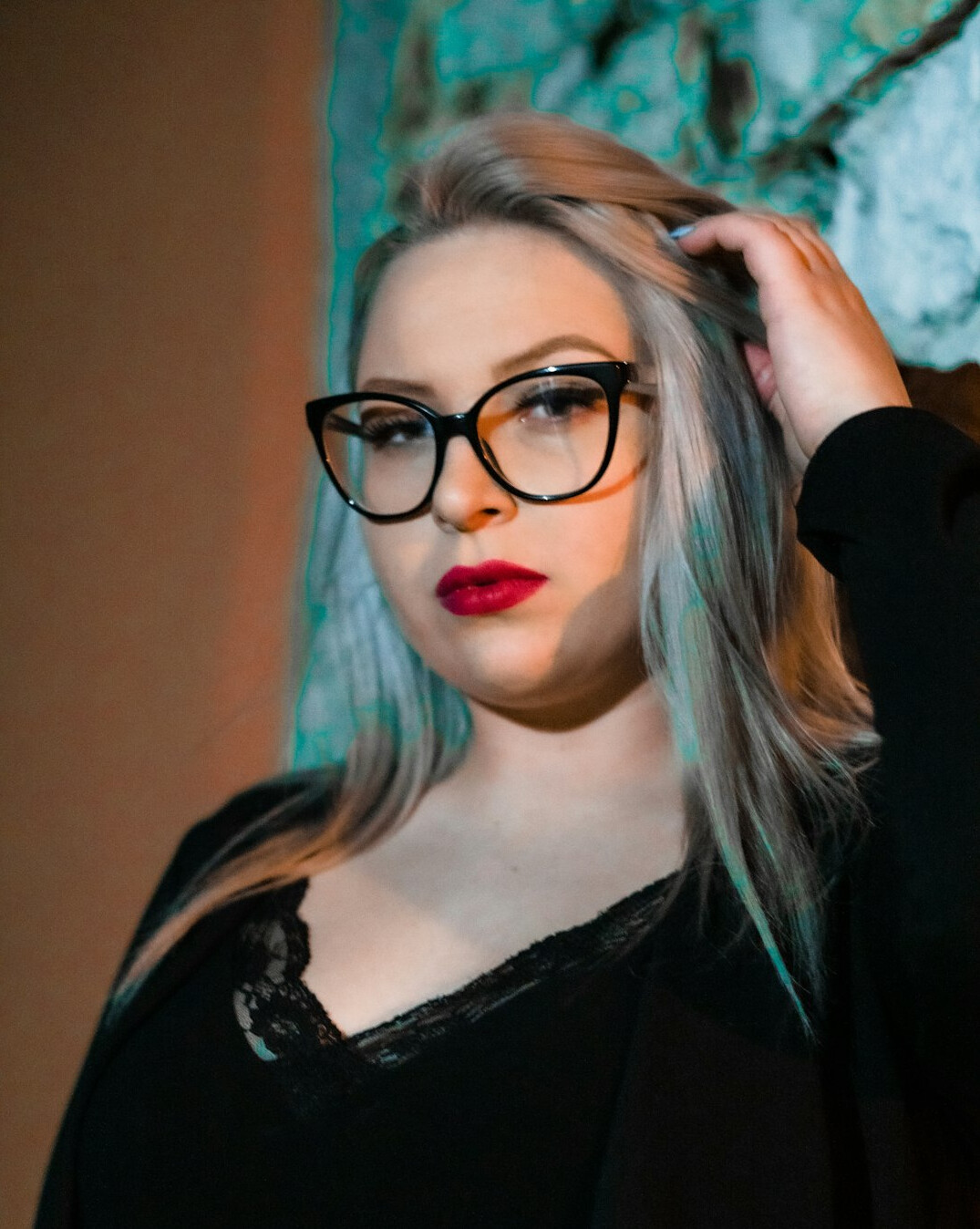 Professional portrait of a composed woman in her forties with glasses and a dark blazer