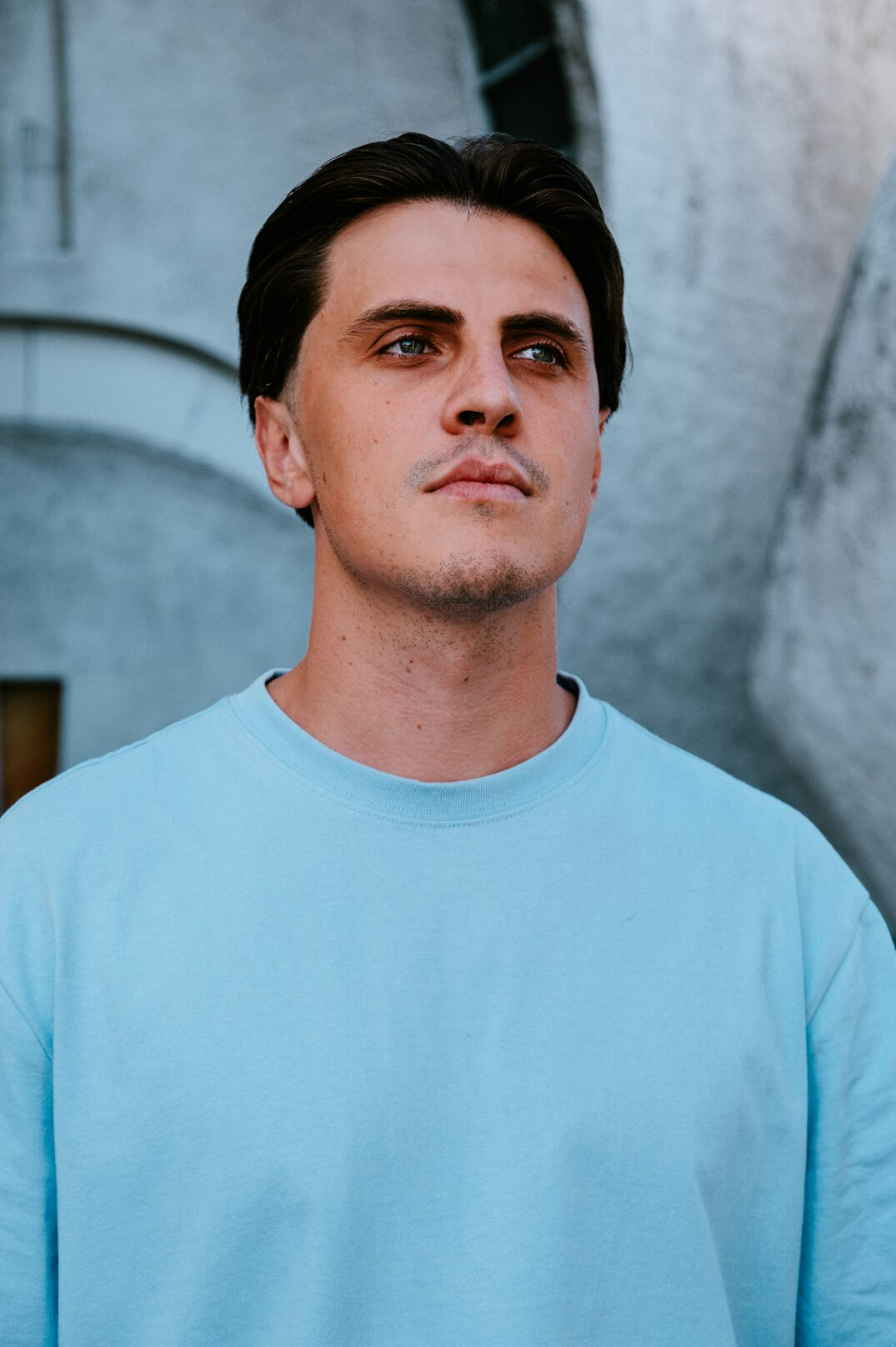 Professional portrait of a friendly man in his thirties with short dark hair and a light blue shirt
